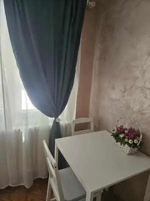 a white table and chairs with a blue curtain at Room Nine in Belgrade