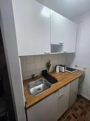 a kitchen with a sink and white cabinets at Room Nine in Belgrade