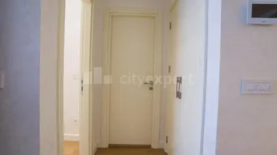 a hallway with a door with a television on it at Exclusive Apartment in Belgrade