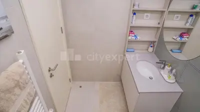 a white bathroom with a sink and a mirror at Exclusive Apartment in Belgrade