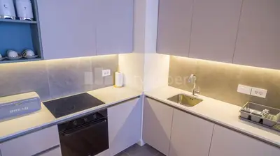 a kitchen with white cabinets and a sink and a stove at Exclusive Apartment in Belgrade