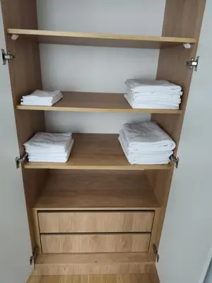 a closet with wooden shelves and folded towels at The Queen at Parkside in Belgrade