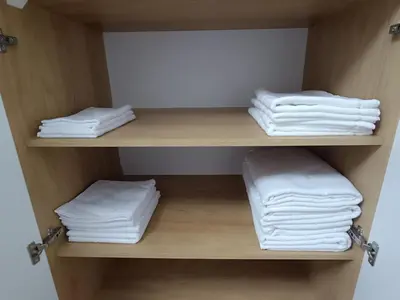 a closet with white towels on a shelf at The Queen at Parkside in Belgrade