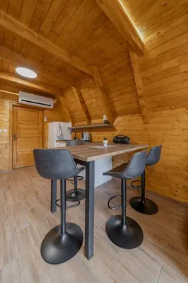 a kitchen with a table and two chairs in a cabin at Nektarija Pool House in Jankoviči