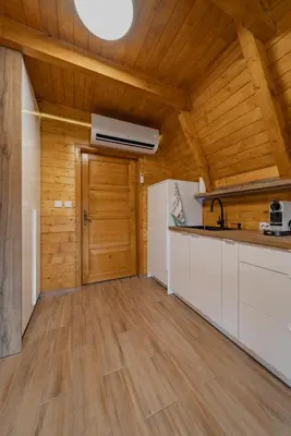 a kitchen with wooden walls and a wooden ceiling at Nektarija Pool House in Jankoviči