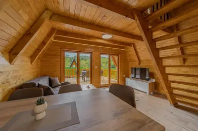 a dining room with a table and chairs in a cabin at Nektarija Pool House in Jankoviči