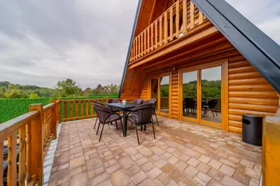 a patio with a table and chairs on a deck at Nektarija Pool House in Jankoviči