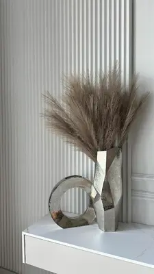 a vase with feathers in it sitting on a table at DOM Boutique Apartments KING'S in Belgrade