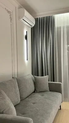 a living room with a couch in front of a window at DOM Boutique Apartments KING'S in Belgrade