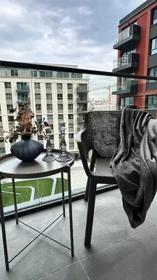 a balcony with a table and a chair and a window at DOM Boutique Apartments KING'S in Belgrade
