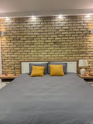 a bedroom with a large bed with two yellow pillows at Maison Dositej No20 in Belgrade