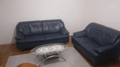 a living room with a black couch and a glass table at Hit in Smederevo