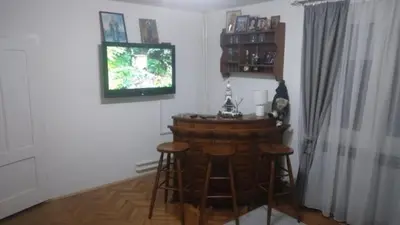a room with a bar with stools and a television at Hit in Smederevo