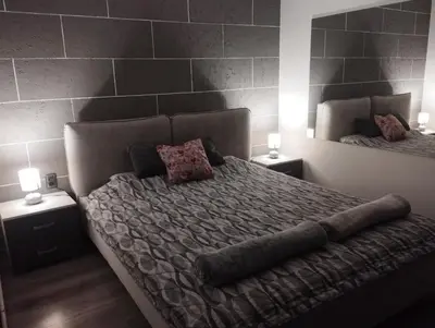 a bedroom with a large bed with two mirrors at DEP House in Beograd