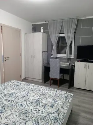 a bedroom with a bed and a table and a desk at DEP House in Beograd