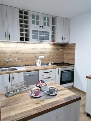 a kitchen with white cabinets and a wooden counter top at DEP House in Beograd