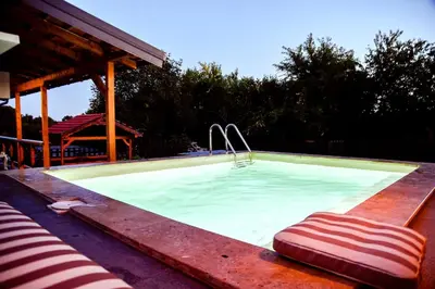 a swimming pool with a bench and a chair in it at Kuca na dan - DIKAN in Ba°evac