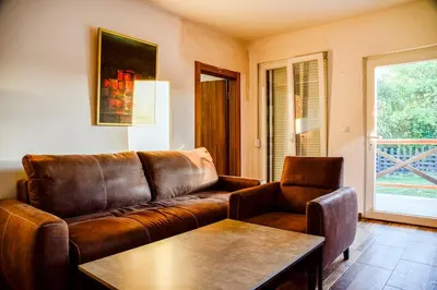 a living room with a brown leather couch and a table at Kuca na dan - DIKAN in Ba°evac