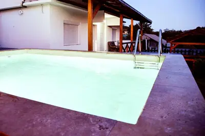 a swimming pool in front of a house at Kuca na dan - DIKAN in Ba°evac
