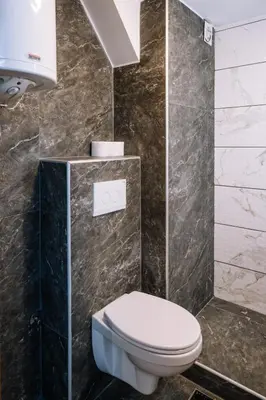 a bathroom with a white toilet and marble walls at Marshal Autokomanda in Belgrade
