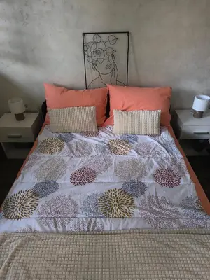 a bed with orange pillows in a bedroom at Nina Urban Apartment-Novi Beograd in Belgrade