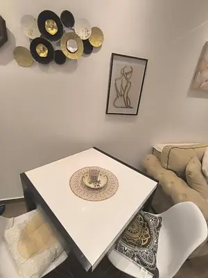 a white table with a plate on it in a living room at Nina Urban Apartment-Novi Beograd in Belgrade