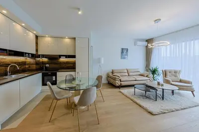 a kitchen and living room with a glass table and chairs at ZIGZAG Belgrade Waterfront King in Belgrade