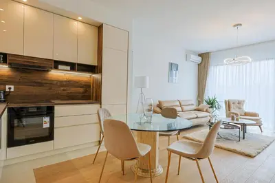 a kitchen and living room with a table and chairs at ZIGZAG Belgrade Waterfront King in Belgrade