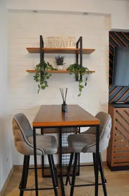 a dining room table with chairs and a sign that reads home at BW Studio Oasis! Garage, Terrace, Kula&Galerija! in Belgrade