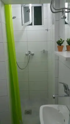 a bathroom with a glass shower with a sink at Santa Maria Apartment in Donji Kovilj