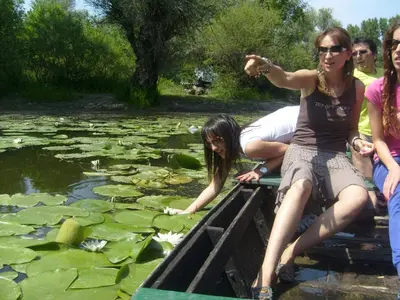a group of people sitting on a boat in a pond at Santa Maria Apartment in Donji Kovilj