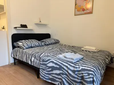 a bedroom with a bed with a striped comforter at Heart Studio in Belgrade