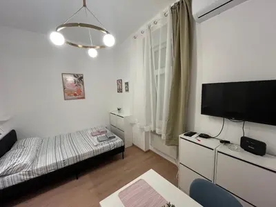 a small room with a bed and a flat screen tv at Heart Studio in Belgrade