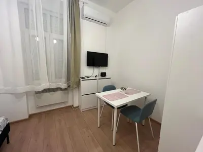 a small white room with a white table and chairs at Heart Studio in Belgrade