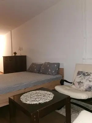 a small bedroom with a bed and a chair at Andrej 62 in Beograd