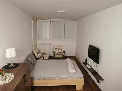 a small bedroom with a bed and a desk at Andrej 62 in Beograd