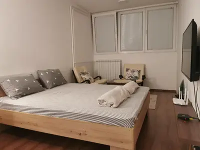 a bedroom with a bed and a flat screen tv at Andrej 62 in Beograd