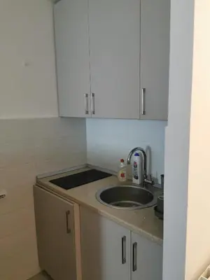 a small kitchen with a sink and white cabinets at Andrej 62 in Beograd