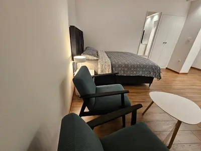 a bedroom with a bed and a chair and a table at Studio 1920 in Belgrade