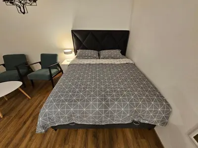 a bedroom with a bed and two chairs and a table at Studio 1920 in Belgrade