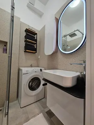 a bathroom with a washing machine and a sink at Studio 1920 in Belgrade