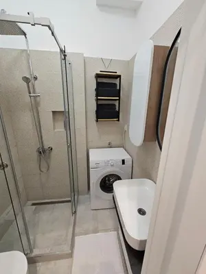 a small bathroom with a shower and a washing machine at Studio 1920 in Belgrade