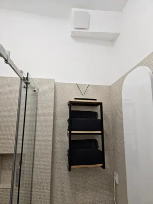 a shelf in a bathroom with a shower and a mirror at Studio 1920 in Belgrade