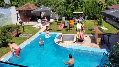 a group of people playing in a swimming pool at etno brvnara sa bazenom in Železnička Stanica Karlovački Vinogradi