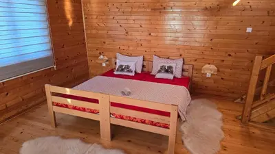 a bedroom with a bed in a log cabin at etno brvnara sa bazenom in Železnička Stanica Karlovački Vinogradi