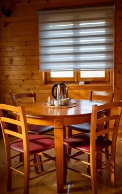 a wooden table with chairs and a tea kettle on it at etno brvnara sa bazenom in Železnička Stanica Karlovački Vinogradi