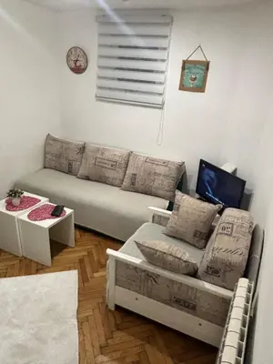 a living room with a couch and a table at Bohemian Rhapsody low ground studio in Belgrade