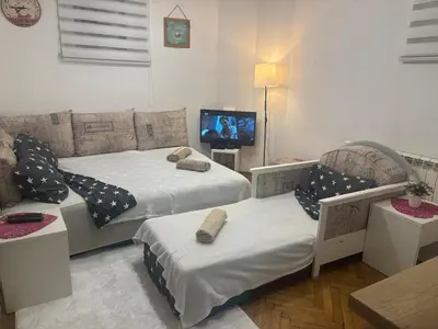 a living room with two beds and a tv at Bohemian Rhapsody low ground studio in Belgrade