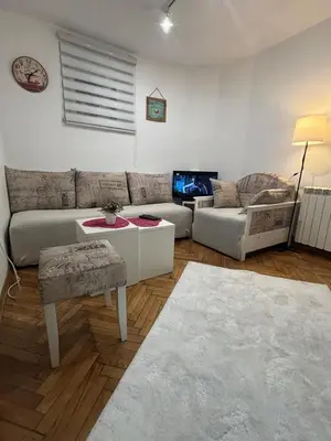 a living room with a couch and a table at Bohemian Rhapsody low ground studio in Belgrade