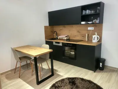 a small kitchen with a table and a sink at Ellie Star Apartment in Belgrade